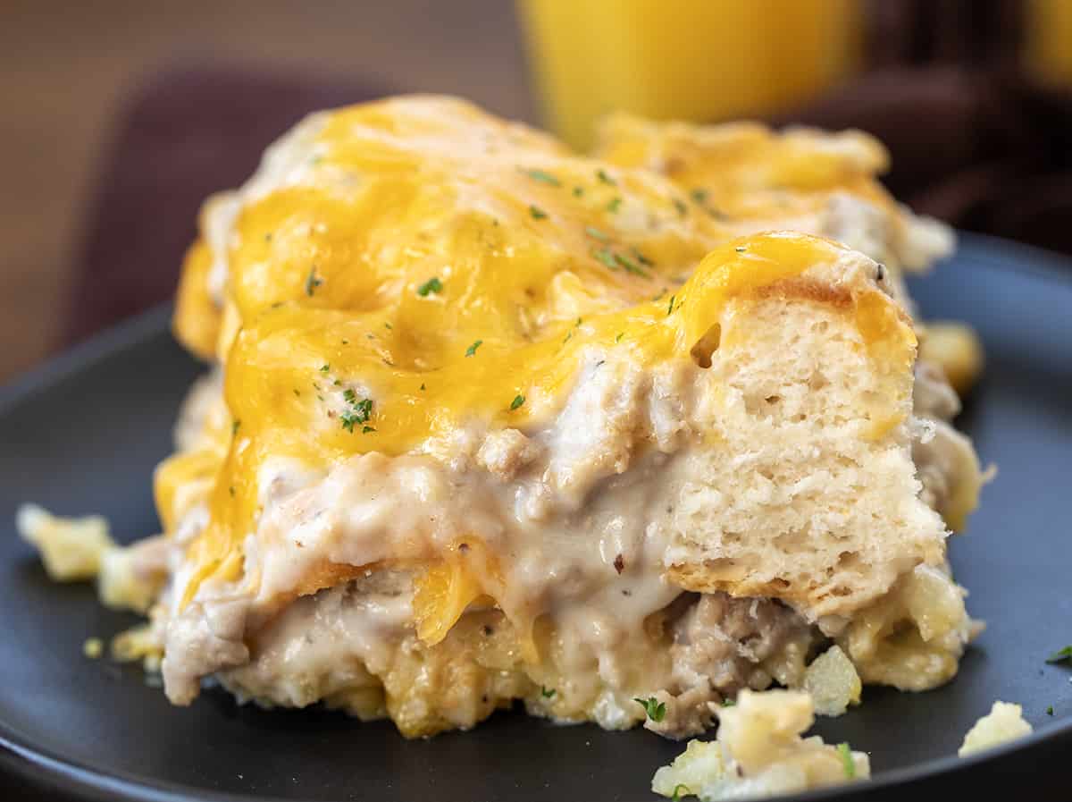 Close up of a piece of Easy Biscuits and Gravy Bake on a black plate.