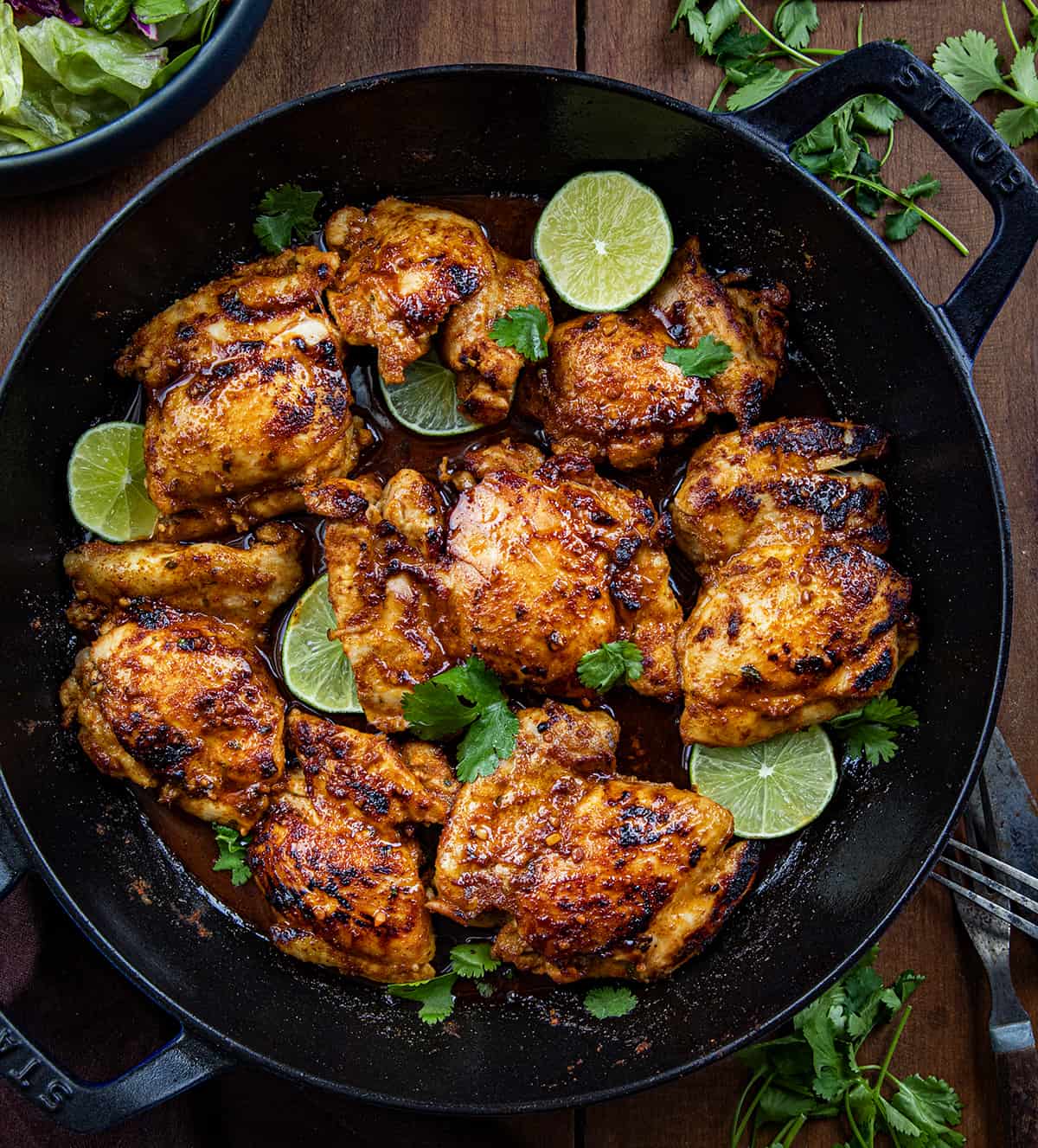 Skillet of Chili Lime Chicken on a wooden table from overhead. 