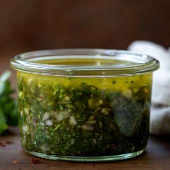 Jar of Chimichurri Sauce on a wooden table.