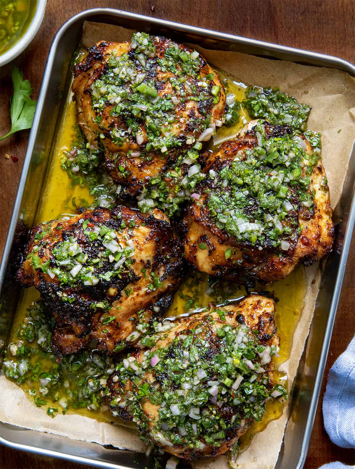 Tray of Chimichurri Chicken on a wooden table from overhead.