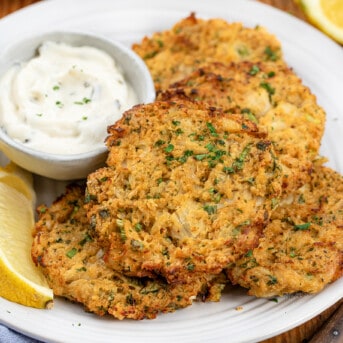 Plate of Crab Cakes with sauce and fresh lemon.