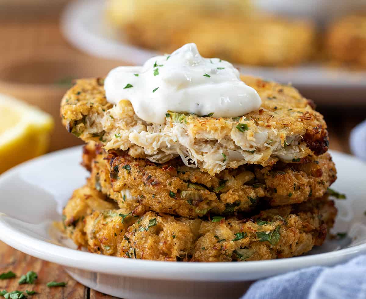Stack of Crab Cakes with top crab cake broken show ing inside texture.