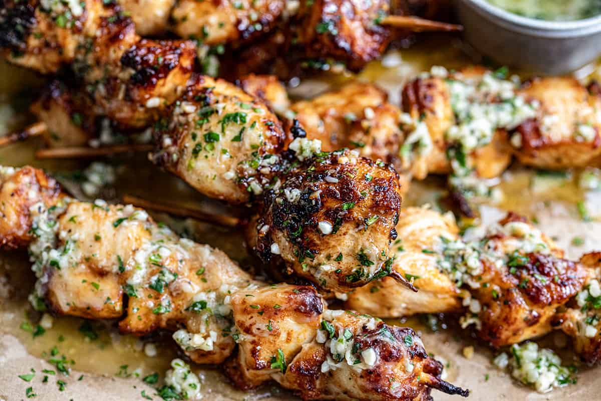 Garlic Parmesan Chicken Skewers on their side on a platter close up.