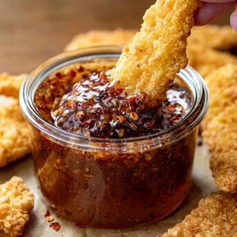 Dipping chicken tender into Hot Honey that hasn't been strained and still has the pepper in it.