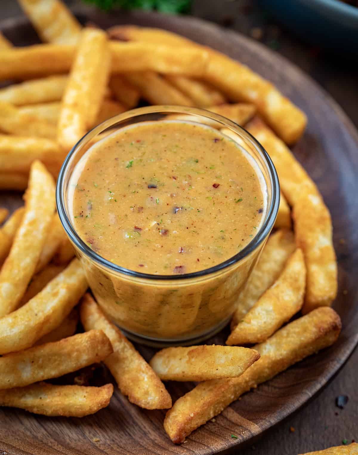 Hot Honey Ranch in a glass cup surrounded by french fries.