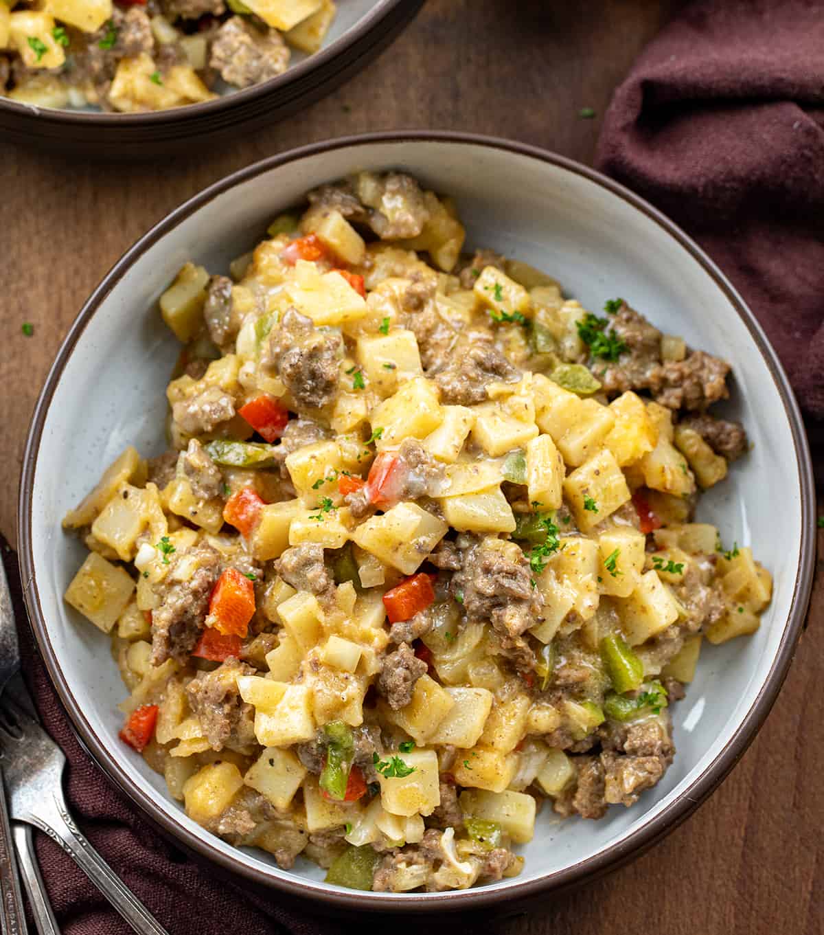 Bowls of Slow Cooker Philly Cheesesteak Casserole on a wooden table. 