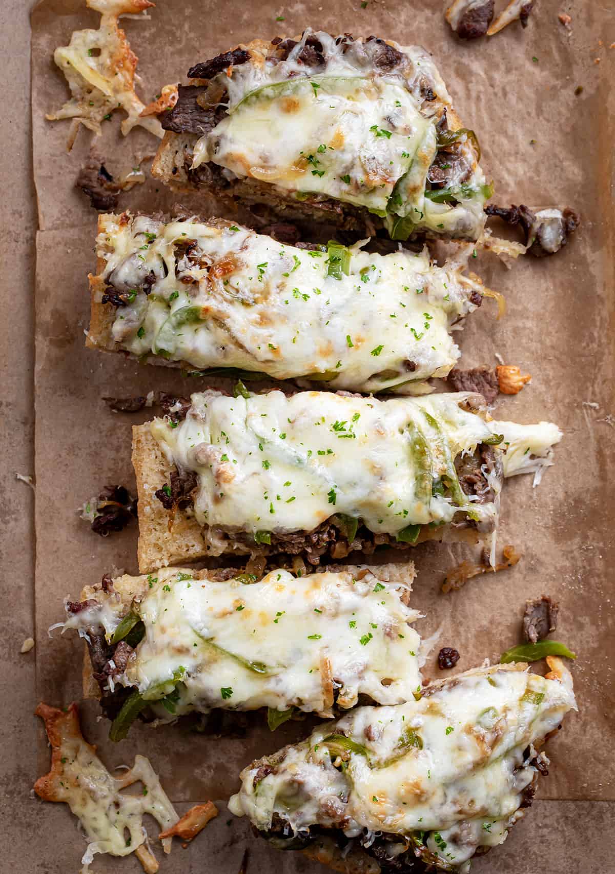 Philly Cheesesteak Garlic Bread on a piece of parchment paper cut into slices.