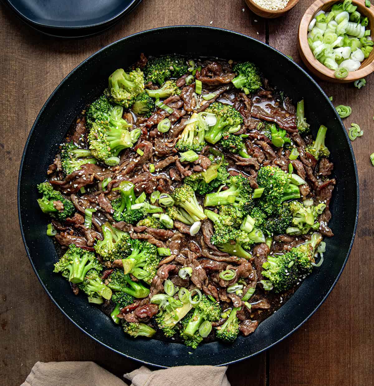 Skillet of Beef and Broccoli on a wooden table from overhead.