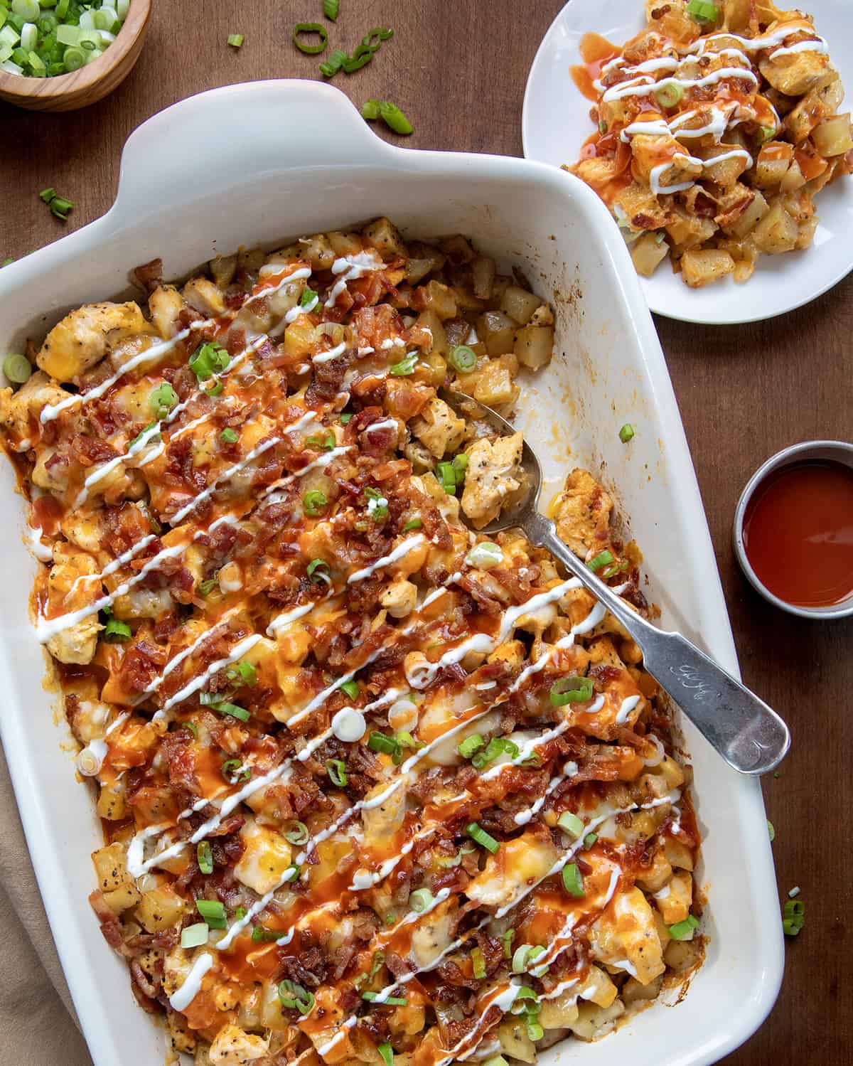 Buffalo Chicken Roasted Potato Bake in a casserole dish on a wooden table from overhead. 