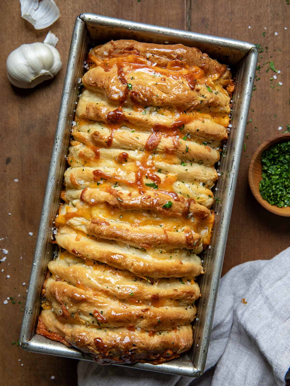 From Scratch Cheesy Garlic Pull-Apart Bread in a pan on a wooden table from overhead. 