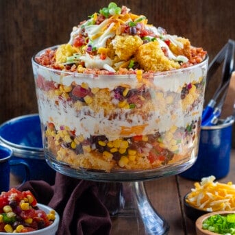 Cowboy Cornbread Trifle on a wooden table with extra ingredient all around it.