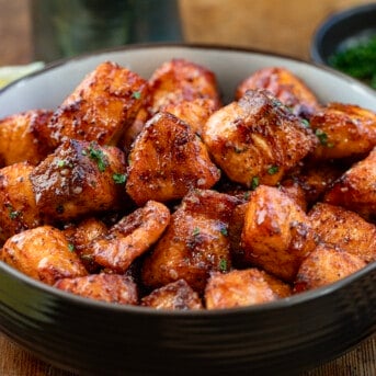 Bowl of Hot Honey Salmon Bites on a wooden table.