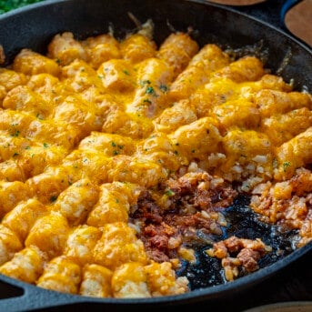 Skillet of Sloppy Joe Tater Tot Casserole with some removed showing the sloppy joe.