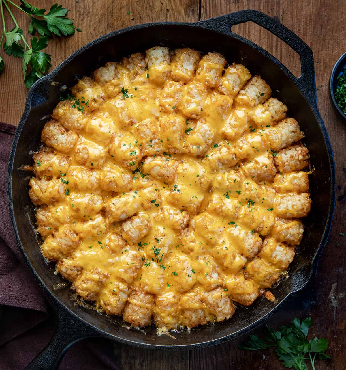 Sloppy Joe Tater Tot Casserole in a skillet on a wooden table from overhead. 