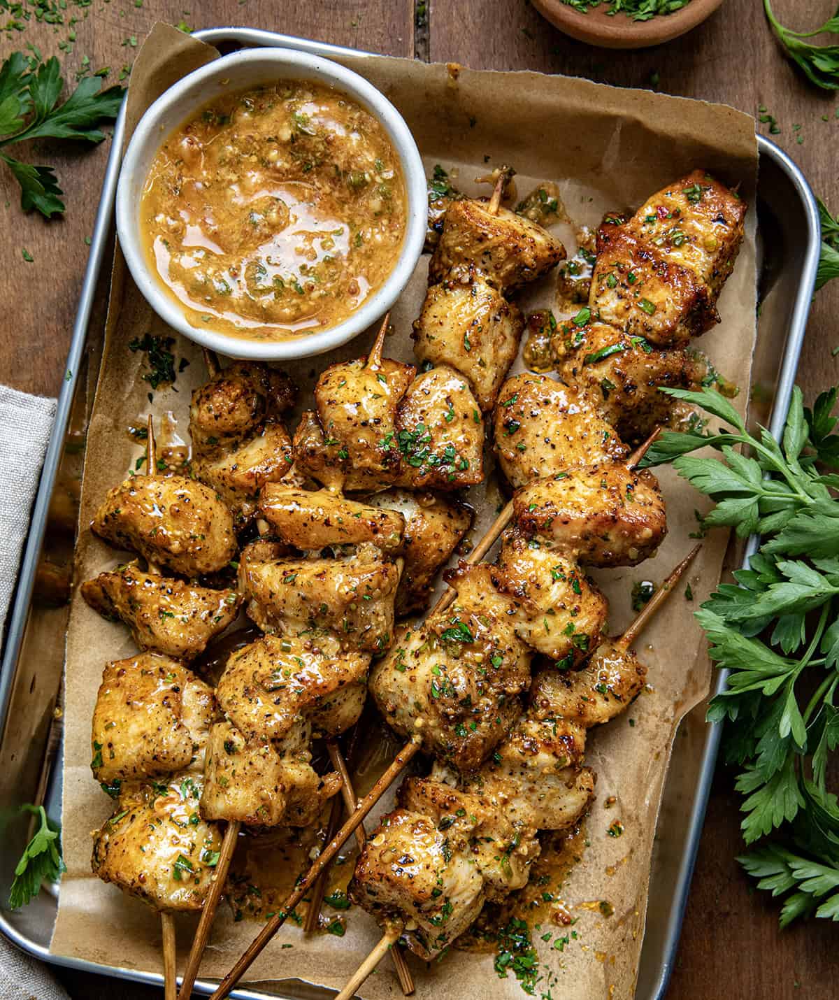 Platter of Cowboy Butter Chicken Skewers next to Cowboy Butter on a wooden table from overhead.