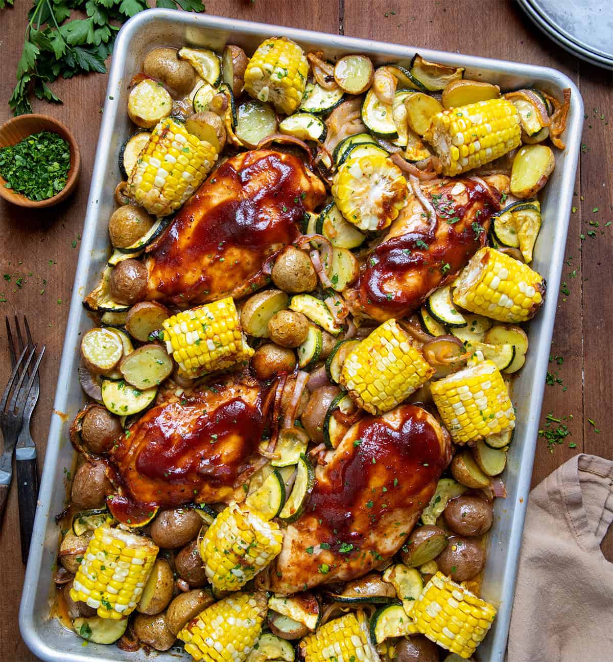 BBQ Chicken Sheet Pan Meal on a wooden table from overhead.