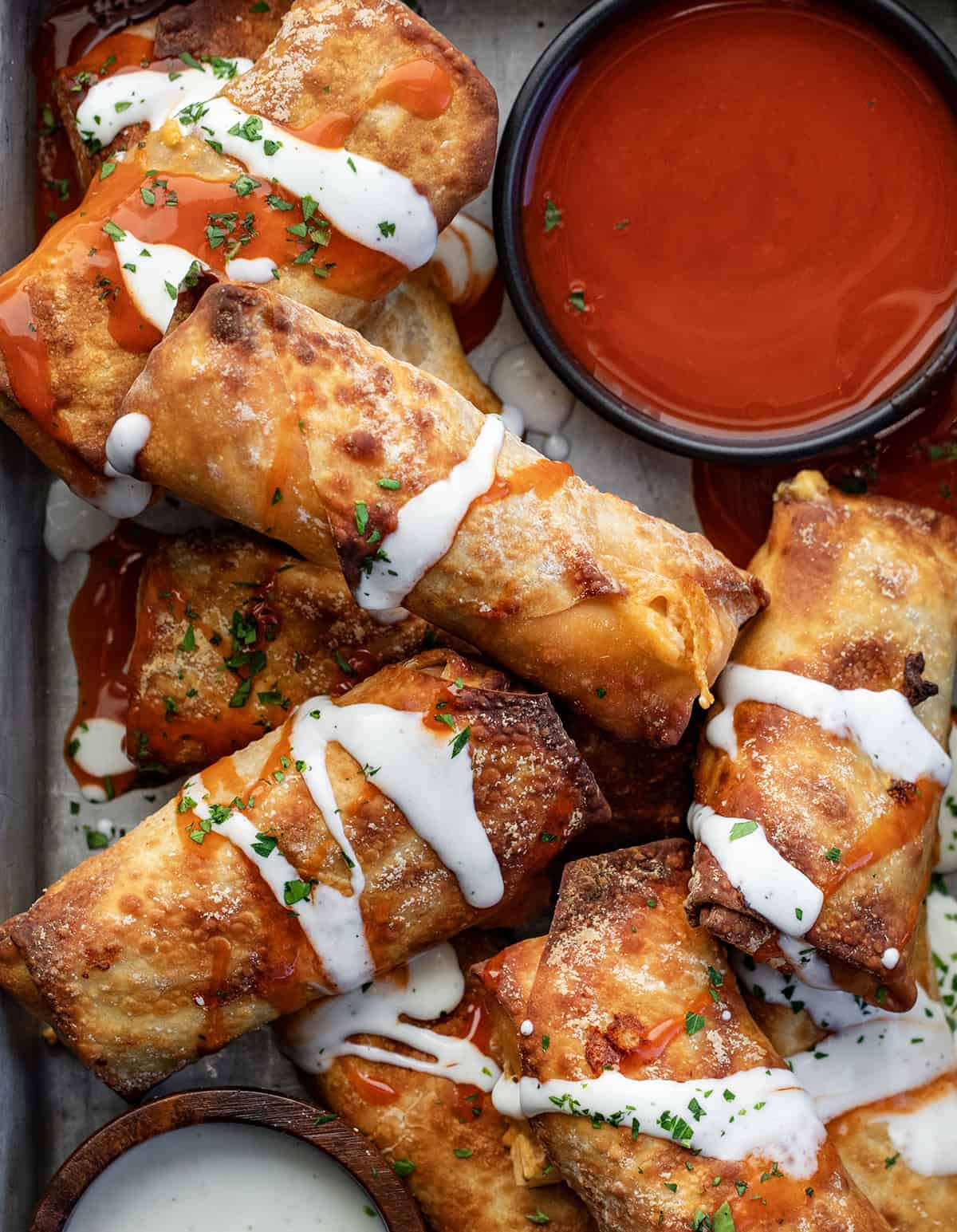 Buffalo Chicken Egg Rolls in a platter on a wooden table from overhead.