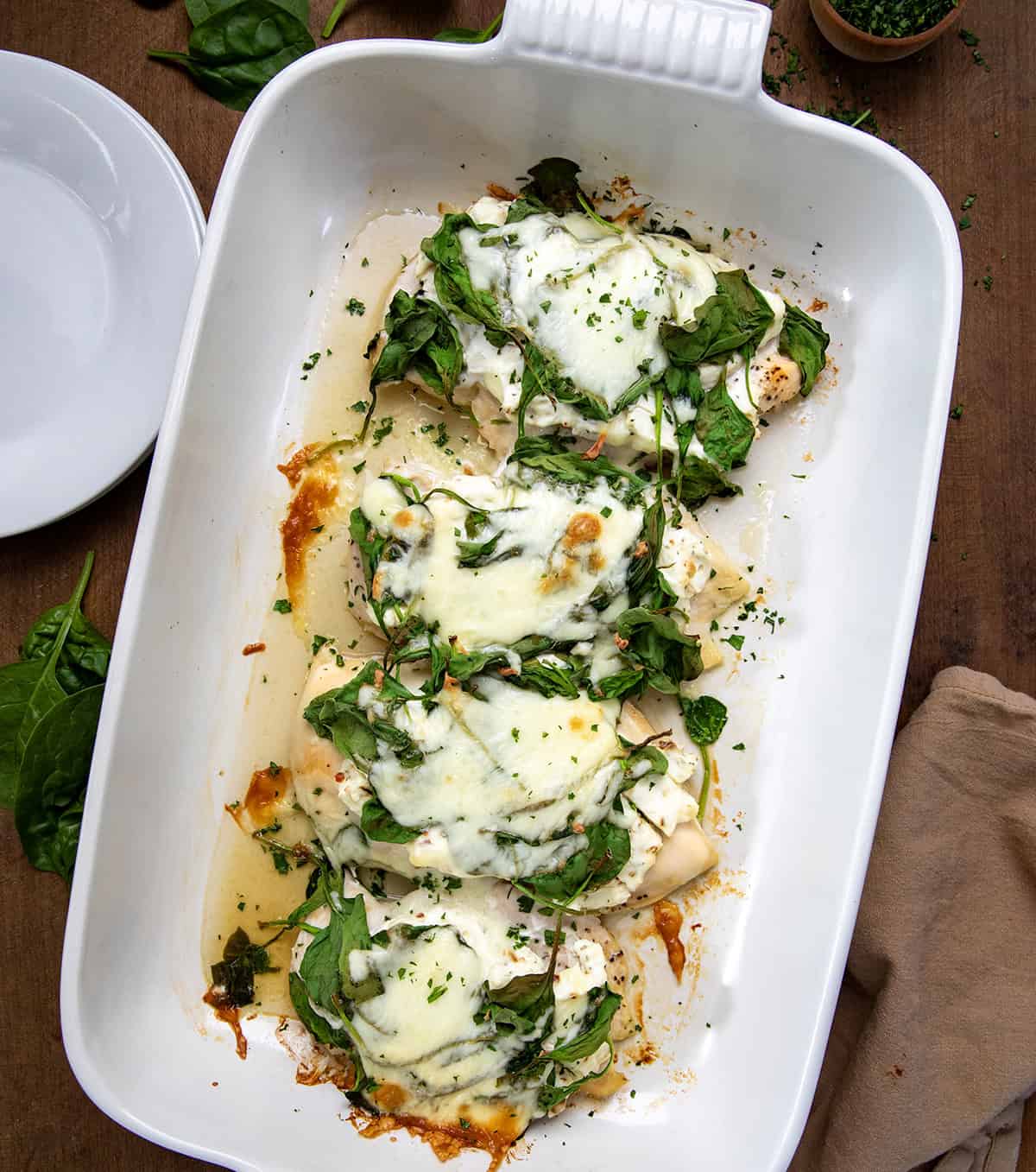 Chicken Spinach Bake on a wooden table in a white pan from overhead.