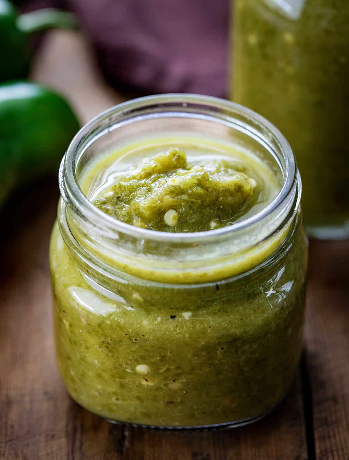 Jar of Jalapeno Hot Sauce on a wooden table.