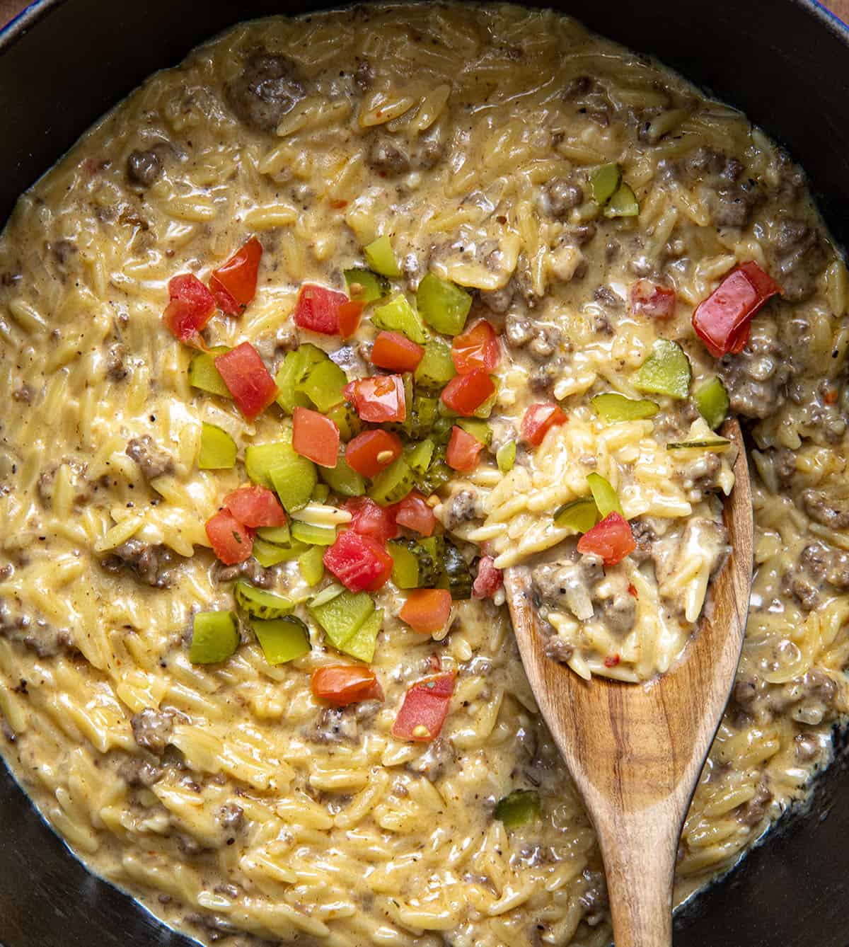 Close up of a pot of Cheeseburger Orzo with a spoon in it showing the creamy texture. 