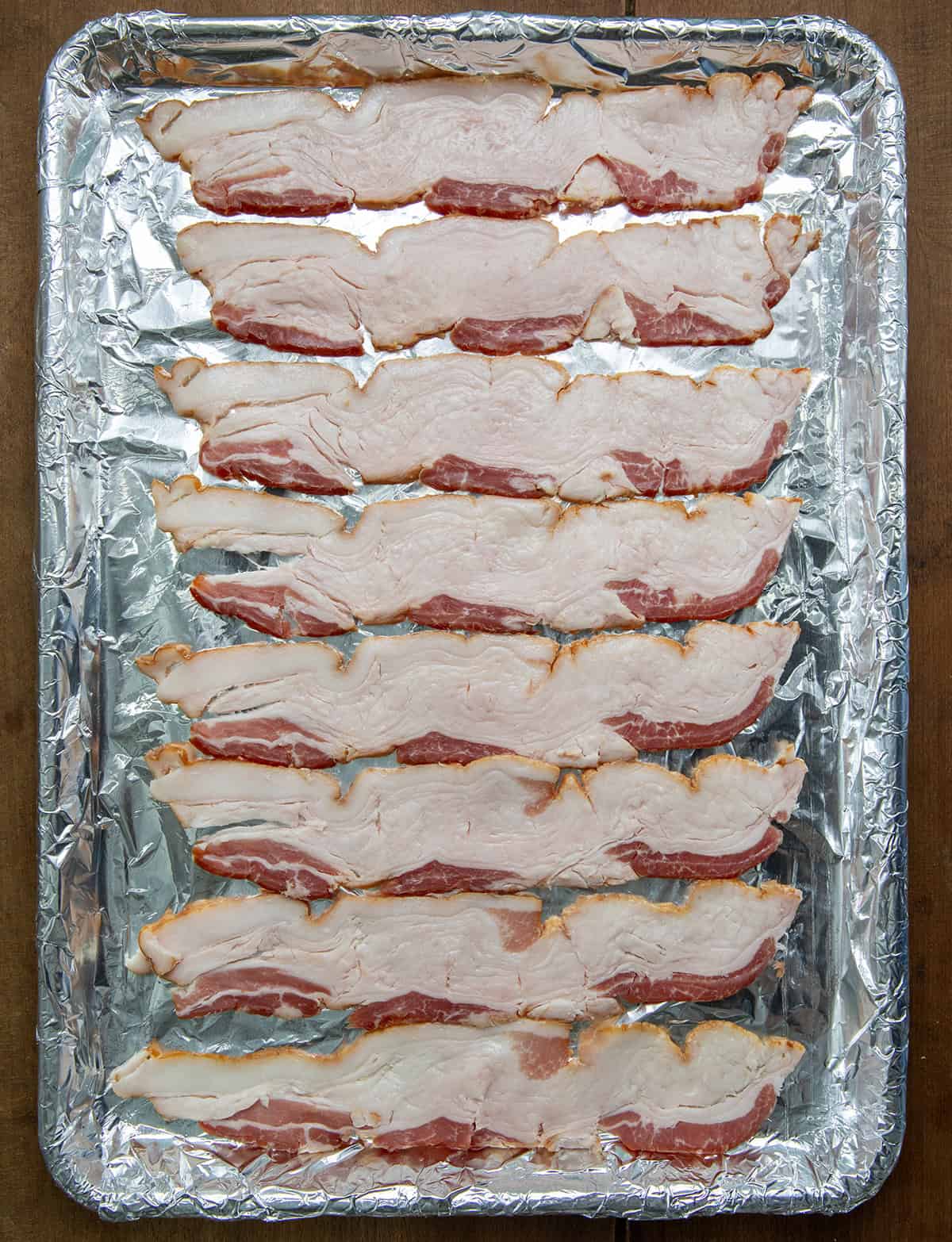 Sheet pan of raw bacon before baking.