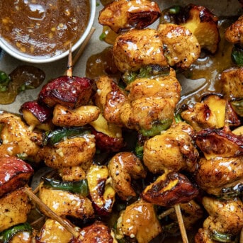 Close up of Jalapeno Peach Chicken Skewers all piled together on a tray.