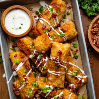 Jalapeno Popper Egg Rolls on a wooden table in a pan from overhead.