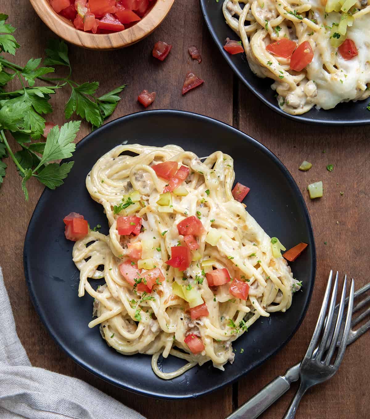 Plates of Cheeseburger Tetrazzini on a wooden table from overhead.