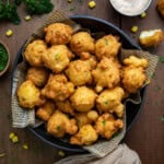 Skillet of Corn Nuggets on a wooden table from overhead.