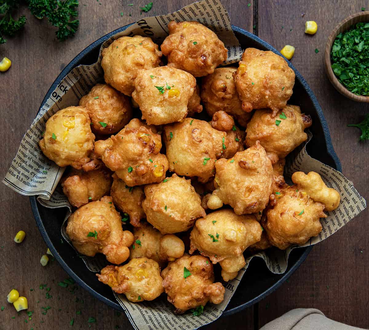 Skillet of Corn Nuggets on a wooden table from overhead.