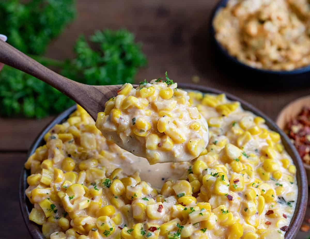 Spoonful of Cowboy Butter Creamed Corn held right over the bowl.