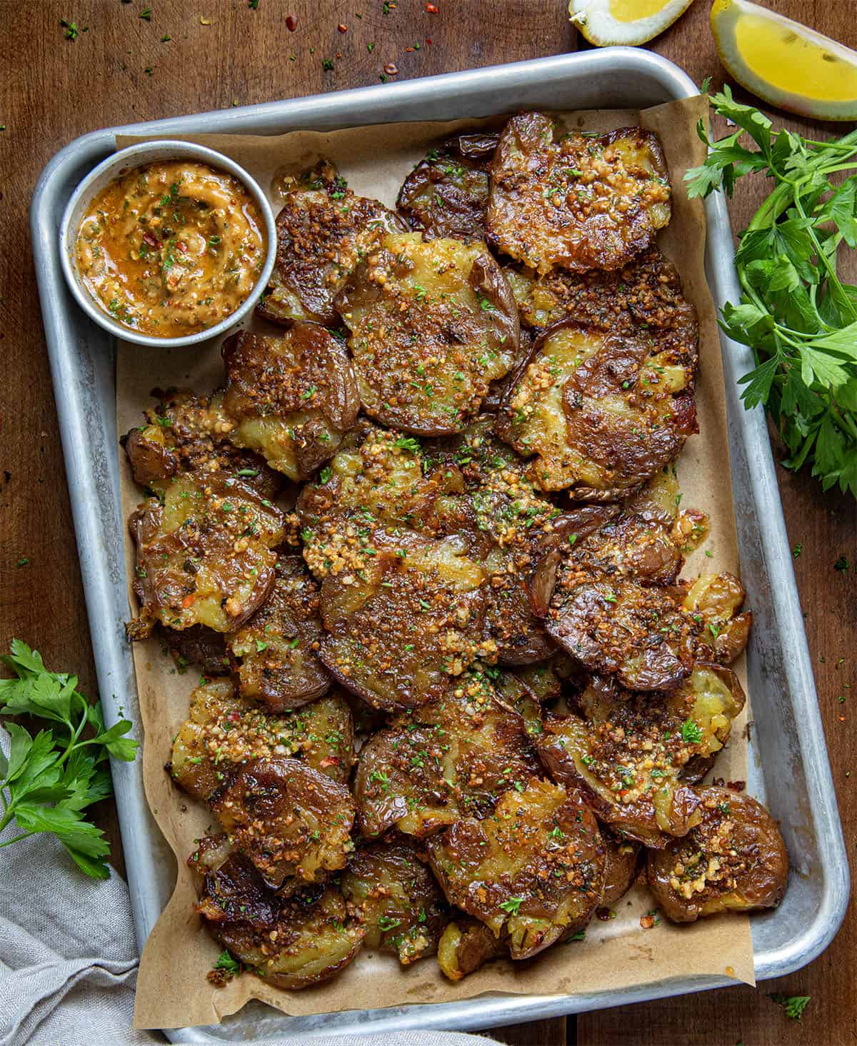 Pan of Cowboy Butter Smashed Potatoes on a wooden table from overhead.