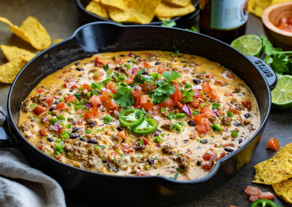 Skillet of Cowboy Queso on a wooden table.