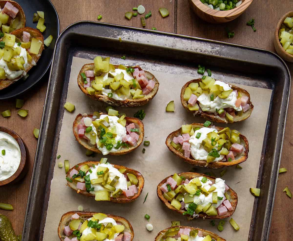 Ham and Pickle Potato Skins on a sheet pan on a wooden table from overhead.