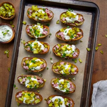 Ham and Pickle Potato Skins on a sheet pan on a wooden table from overhead.