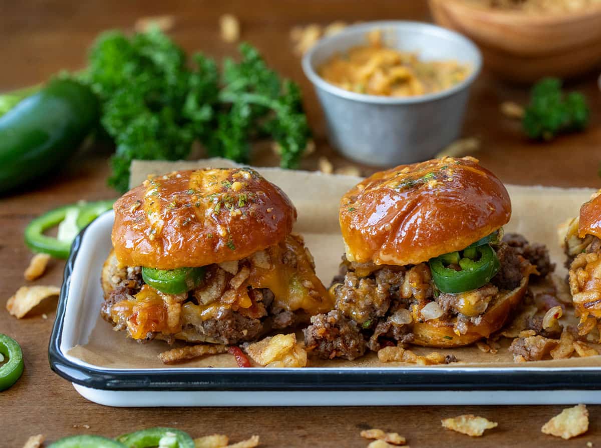 Pretzel Cowboy Sliders on a tray on a wooden table.