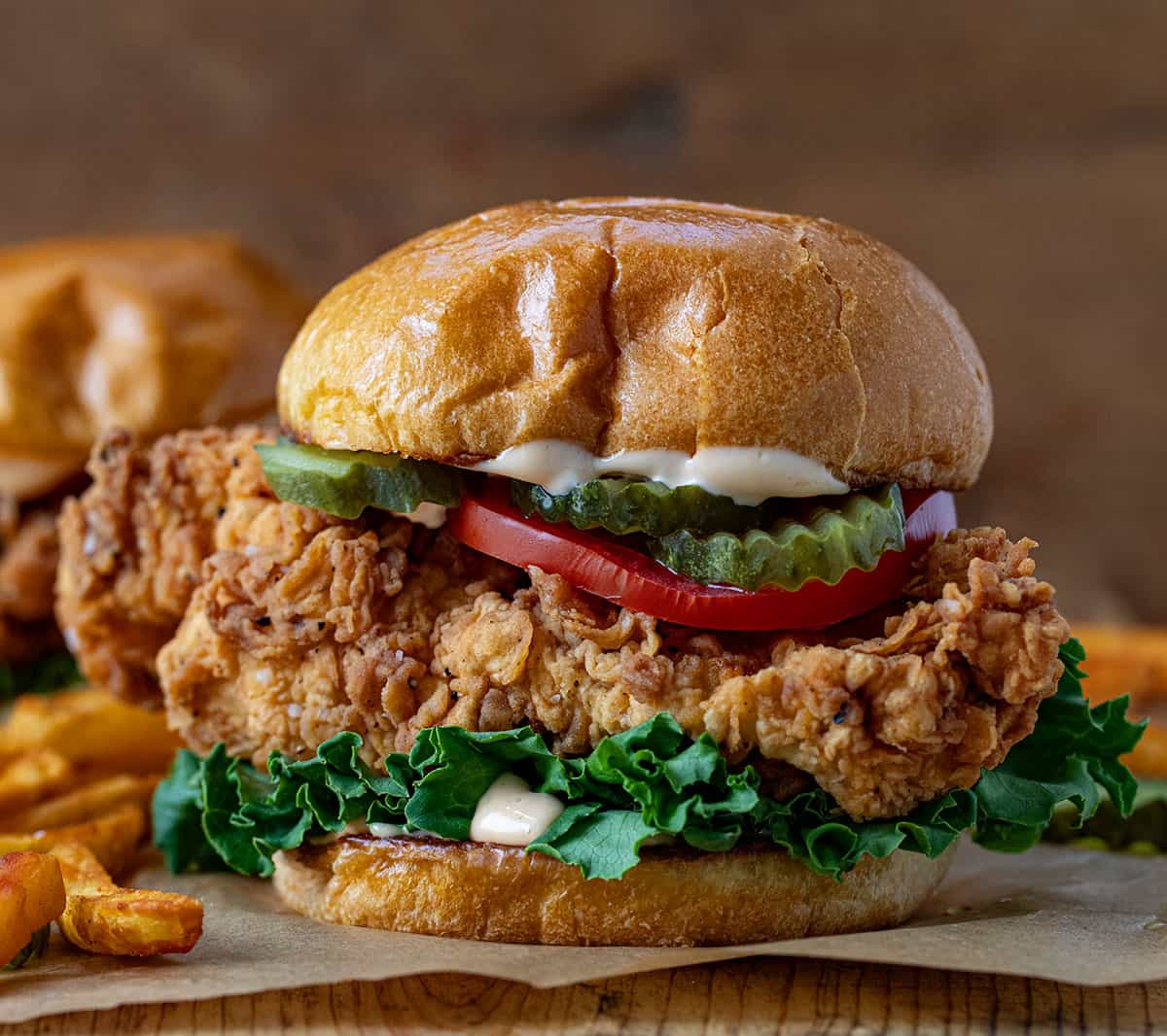 Spicy Chicken Sandwich on a wooden table very close up showing the crispy chicken.