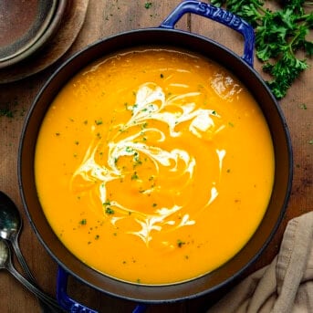 Pot of Butternut Squash Soup on a wooden table from overhead.