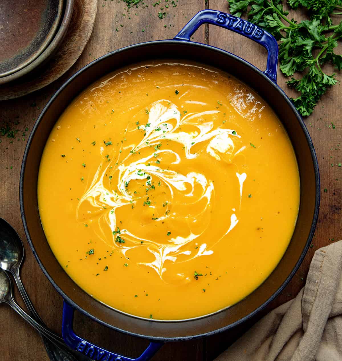 Pot of Butternut Squash Soup on a wooden table from overhead. 