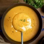 Ladle of Butternut Squash Soup held above the pot.