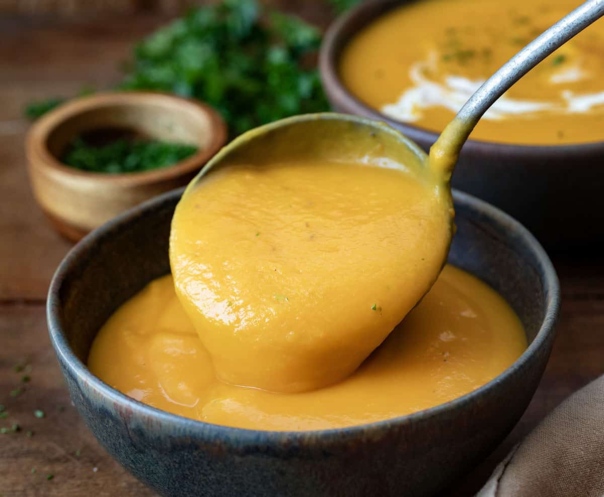 Ladling Butternut Squash Soup into a bowl.