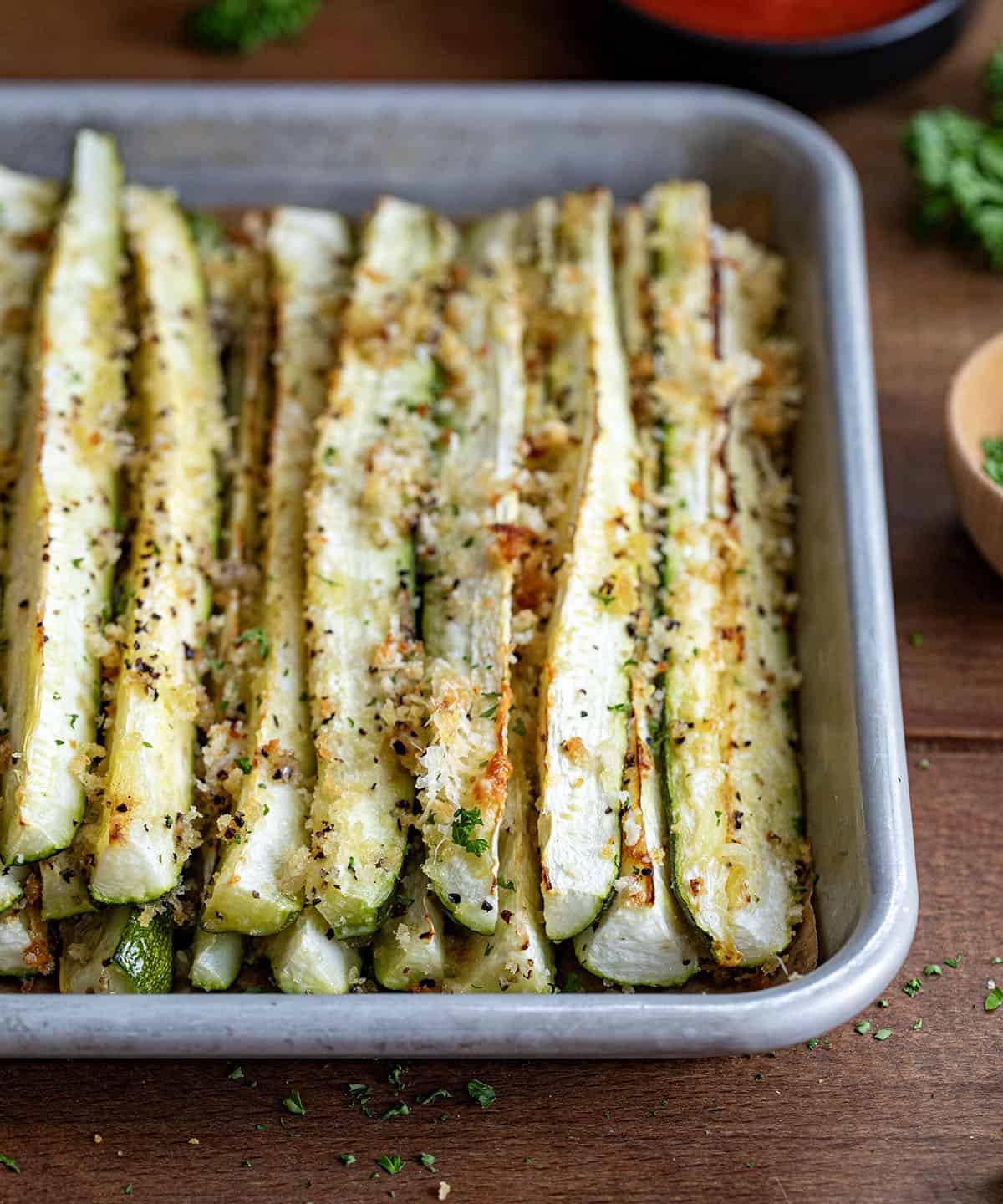 Close up of Baked Zucchini Sticks on a wooden table.