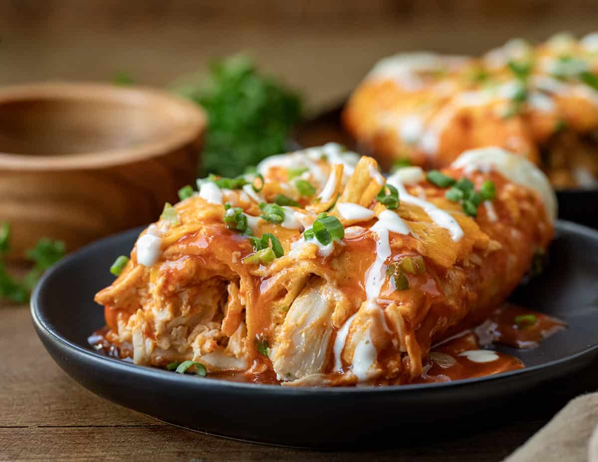 Close up of the inside of Buffalo Chicken Enchiladas on a black plate.