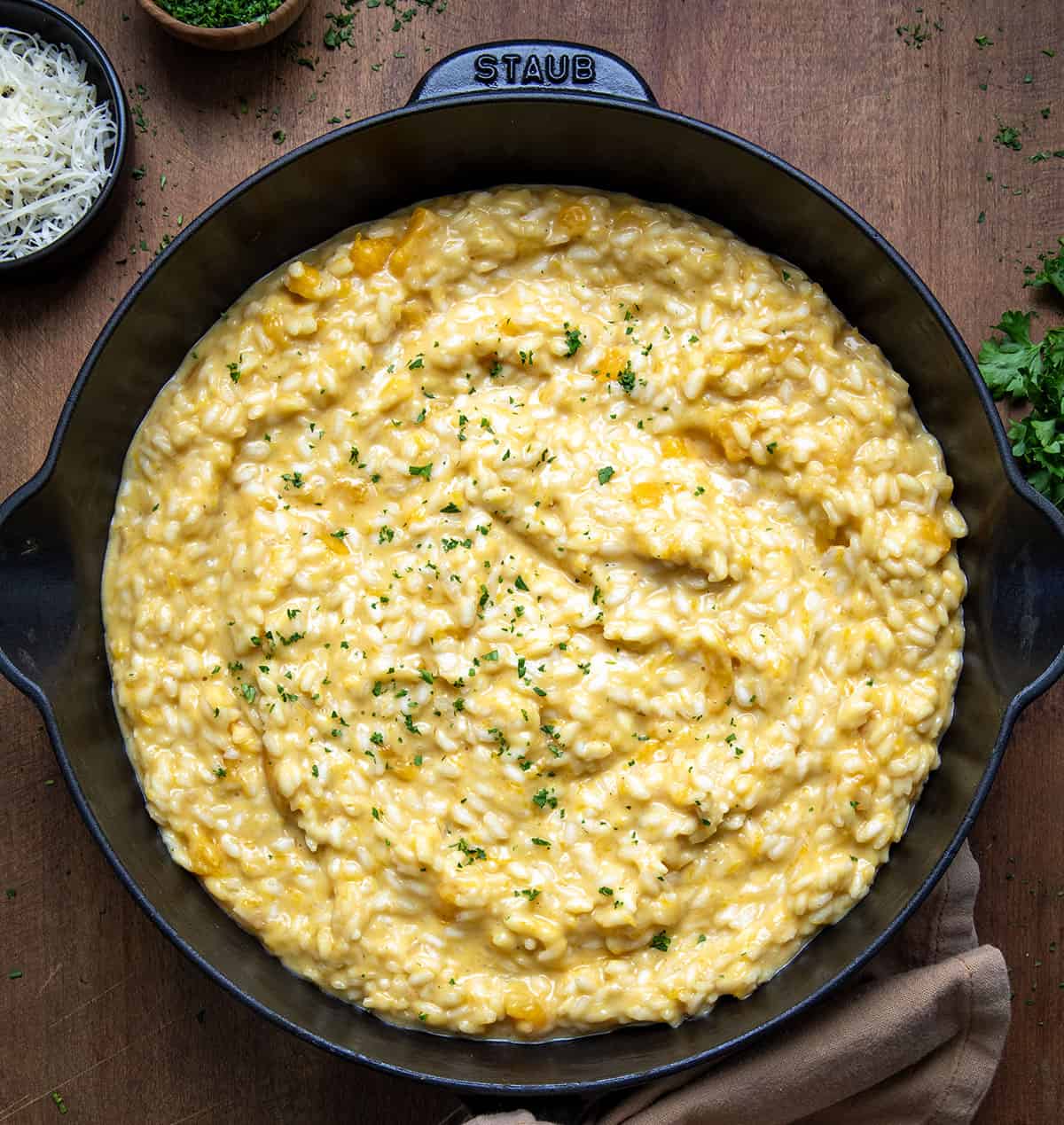 Skillet of Butternut Squash Risotto on a wooden table from overhead.