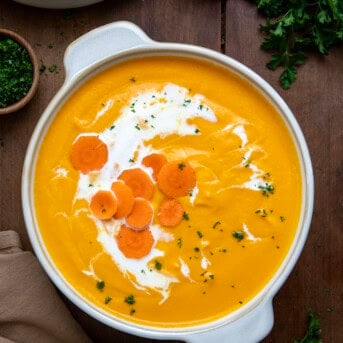 Pot of Carrot Soup on a wooden table from overhead.