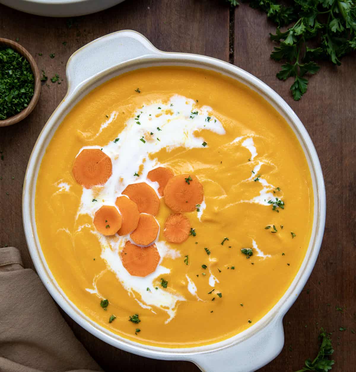 Pot of Carrot Soup on a wooden table from overhead. 