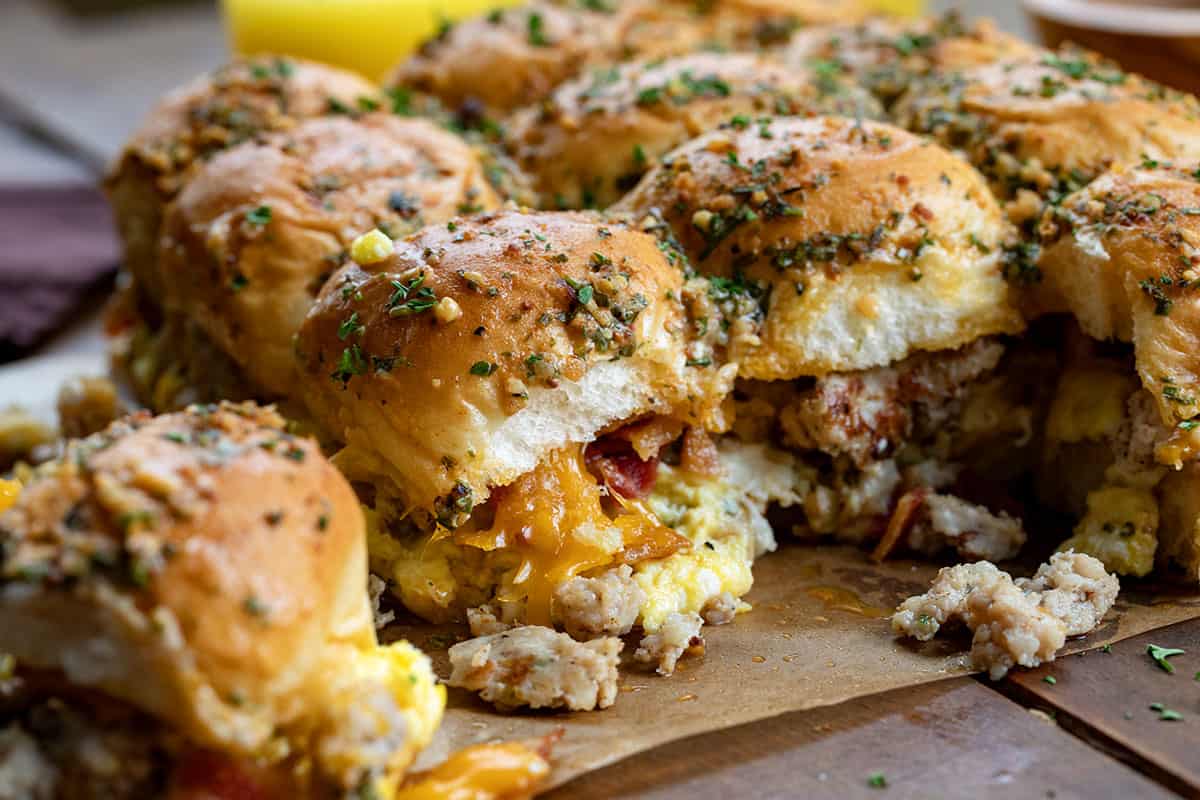 Cowboy Breakfast Sliders on a wooden table on parchment paper with all the ingredients in full view.