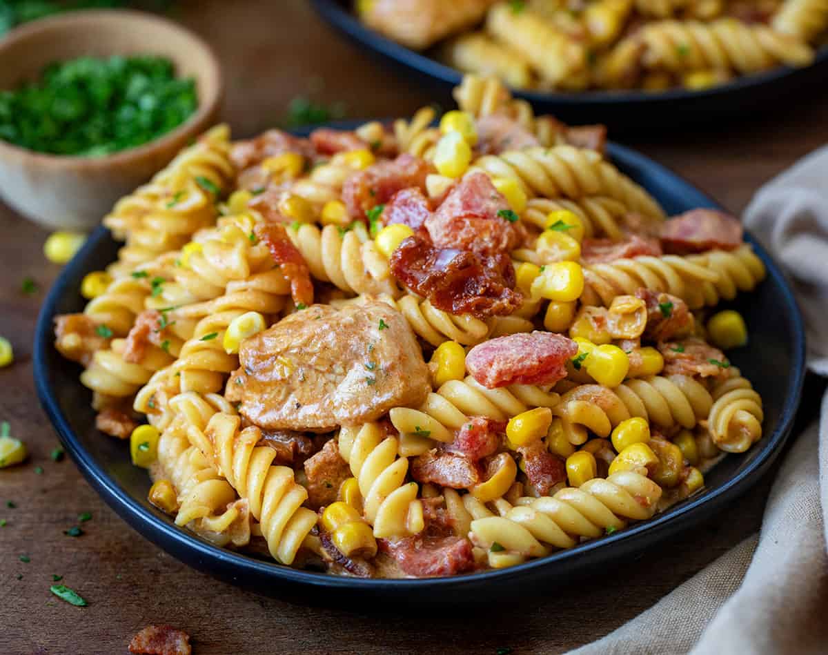 Plate of Creamy Chicken and Bacon Pasta on a wooden table.