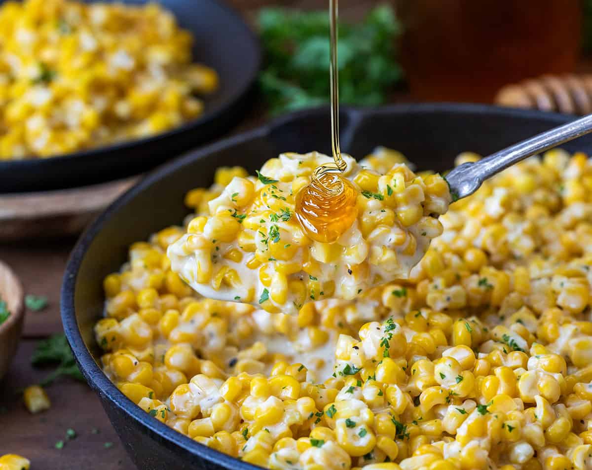 Drizzling honey over a spoonful of Honey Butter Skillet Corn.