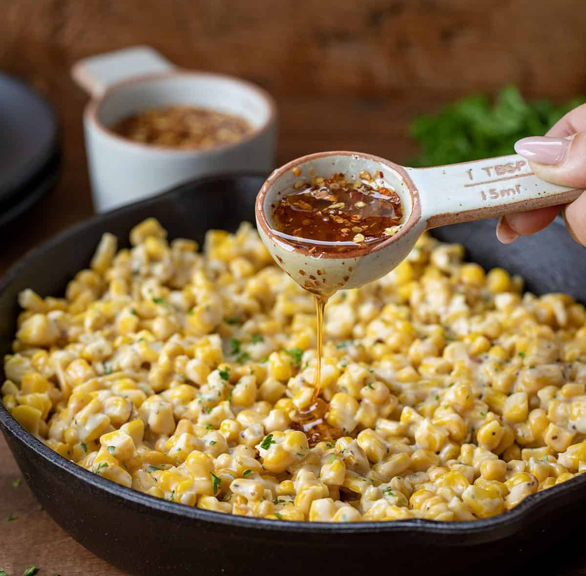 Drizzling hot honey over skillet corn.